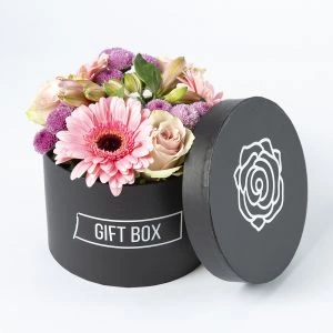 Roze bloemstukje in een zwart hoedendoosje (vooraanzicht)