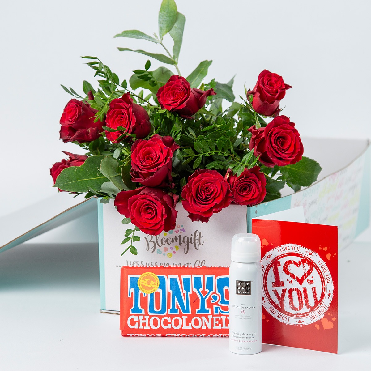 Rode rozen gecombineerd met kaartje en cadeau